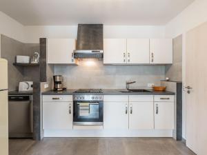 - une cuisine avec des placards blancs et un évier dans l'établissement Bright apartment in a district of Ilmenau, à Stützerbach