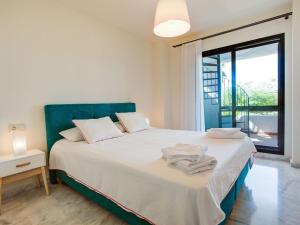 1 dormitorio con 1 cama blanca grande y ventana en Spacious Apartment in San Roque with Swimming Pool, en San Roque