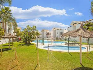 un complejo con piscina con columpios y sombrillas en Spacious Apartment in San Roque with Swimming Pool, en San Roque