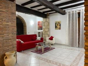 a living room with a red couch and a table at La Fanciulla Velca in Tarquinia