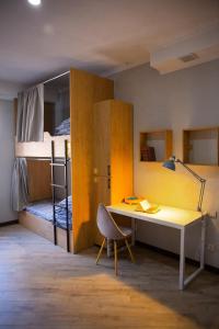 ビシュケクにあるPeople Hostelのデスク、二段ベッドが備わる客室です。