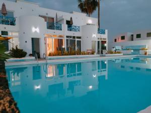 a villa with a swimming pool in front of a house at BLU in Puerto del Carmen