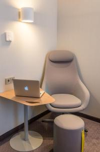 ミュンヘンにあるホリデイイン エクスプレス ミュンヘン シティ ウエストの机上に椅子とノートパソコンを設置したオフィス