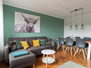 a living room with a couch and a cow on the wall at Tranquil Apartment in Marktleuthen near River and Forest in Marktleuthen