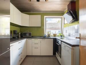a kitchen with white cabinets and a window at Tranquil Apartment in Marktleuthen near River and Forest in Marktleuthen