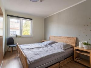 a bedroom with a bed and a chair and a window at Tranquil Apartment in Marktleuthen near River and Forest in Marktleuthen