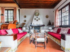 sala de estar con sofás rojos y chimenea en Belvilla by OYO Can Soler, en Sant Iscle de Vallalta
