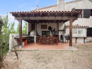 une pergola sur une terrasse en face d'une maison dans l'établissement Belvilla by OYO Can Soler, à Sant Iscle de Vallalta