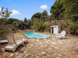 une piscine avec deux chaises longues et une piscine dans l'établissement Belvilla by OYO Can Soler, à Sant Iscle de Vallalta