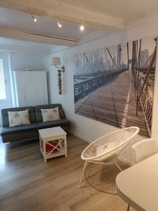 una sala de estar con sofá y una pintura de un muelle en La Mer en Ville, en Marsella