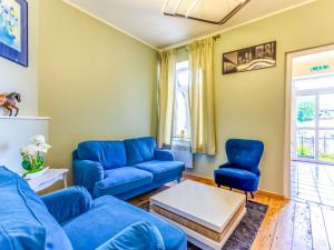 - un salon avec des canapés et des chaises bleus dans l'établissement Spacious Cottage in Harz with Garden and Barbecue, à Harzé