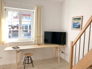 a desk with a television in a room with a window at Galeriestudio - Zentral in Gmund in Gmund am Tegernsee