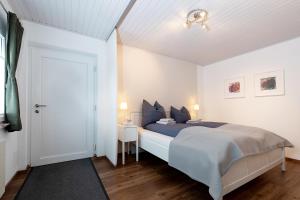 ein weißes Schlafzimmer mit einem Bett und einer weißen Tür in der Unterkunft Apartment Bianca in Salzburg