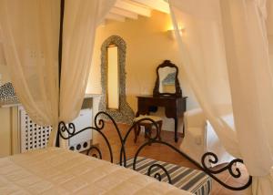 a bedroom with a bed and a table and mirror at Suites of the Gods Cave Spa Hotel in Megalokhori