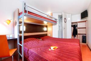 - une chambre avec des lits superposés et un couvre-lit rouge dans l'établissement Premiere Classe Dunkerque Est Armbouts Cappel, à Armbouts-Cappel