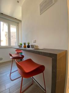 una cucina con due sedie rosse e un bancone di Alloggio Urbano - Centro Storico a Terni