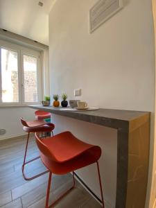 a kitchen with two red chairs and a counter at Alloggio Urbano - Centro Storico in Terni