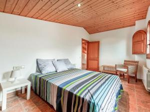 Belvilla by OYO Can Pere Castanyer في مونتسيني: غرفة نوم بسرير وسقف خشبي