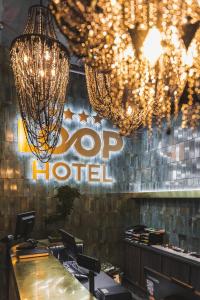 a restaurant with a hog hotel sign and chandeliers at Loop Hotel Vilnius in Vilnius