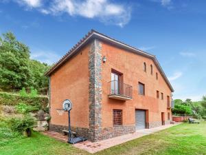 un edificio de ladrillo con un aro de baloncesto delante de él en Holiday Home Montseny with Pool, en Montseny