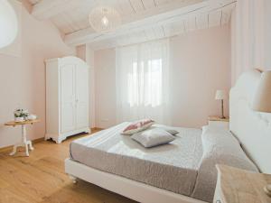 ein weißes Schlafzimmer mit einem Bett und einem Fenster in der Unterkunft Belvilla by OYO Ca Luigi in Acqualagna