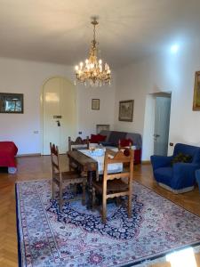 sala de estar con mesa, sillas y lámpara de araña en Villa Il Padule, en Bagno a Ripoli