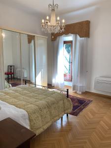 Un dormitorio con una cama grande y una lámpara de araña. en Villa Il Padule en Bagno a Ripoli