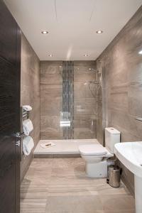 a bathroom with a toilet and a tub and a sink at Cavern Quarter apartments by The Castle Collection in Liverpool