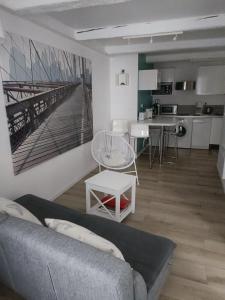 uma sala de estar com um sofá e uma cozinha em La Mer en Ville em Marselha