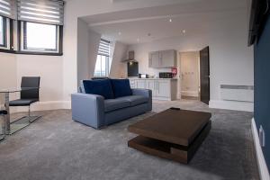 a living room with a blue couch and a table at Cavern Quarter apartments by The Castle Collection in Liverpool