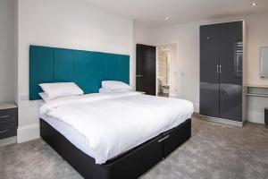 a large bed with a blue headboard in a bedroom at Cavern Quarter apartments by The Castle Collection in Liverpool