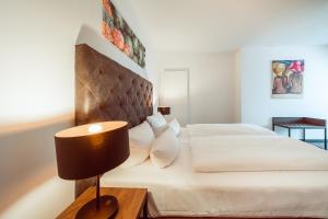 a bedroom with a large white bed and a lamp at Familienapartment Am Neumarkt ll in Dresden