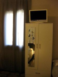 una camera da letto con televisore sopra un comò di Low Cost Ferrara a Ferrara