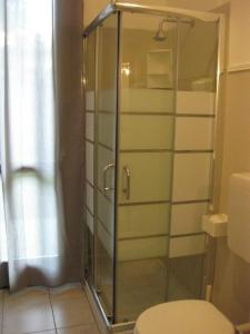 a bathroom with a glass shower with a toilet at Low Cost Ferrara in Ferrara