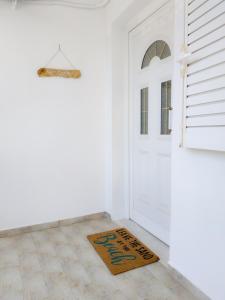 una alfombra de bienvenida frente a una puerta blanca en Mario's Luxury Maisonette en Neos Marmaras
