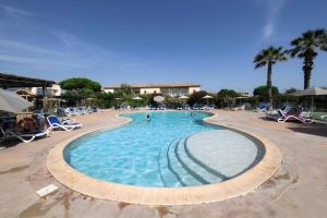 a large swimming pool in a resort with palm trees at Belambra Clubs Résidence Le Grau Du Roi - Le Vidourle in Le Grau-du-Roi