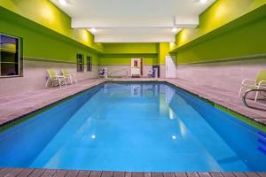 a large swimming pool with blue water in a building at La Quinta by Wyndham Tumwater - Olympia in Tumwater