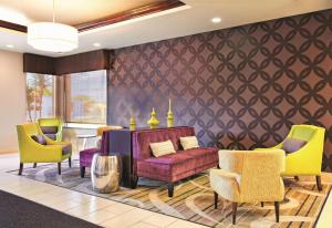 a living room with a purple couch and yellow chairs at La Quinta by Wyndham Tampa Bay Area-Tampa South in Tampa