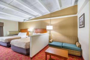 a hotel room with two beds and a couch at Quality Inn & Suites Kansas City - Independence I-70 East in Independence +25 photos