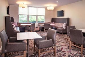 a waiting room with couches and tables and chairs at Sonesta ES Suites Baltimore BWI Airport in Linthicum Heights