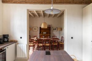 Gite de Vonnes في Pont-de-Ruan: مطبخ وغرفة طعام مع طاولة وكراسي