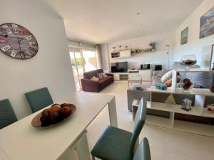 ein Wohnzimmer mit einem Tisch und einer Uhr an der Wand in der Unterkunft Acogedor apartamento con piscina en tamariu in Tamariu