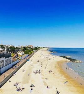 a group of people on a beach near the ocean at Lovely family home, 5 minutes from the beach in Clacton-on-Sea