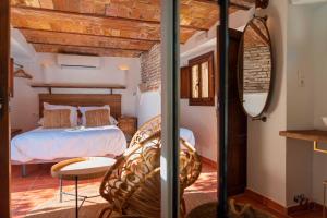 um quarto com uma cama e um espelho em CANDIL SUITE Realejo em Granada