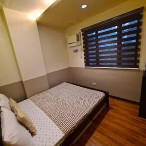 a bed in a room with a large window at 722 Metropolis Tower Unit 212 in Bacolod