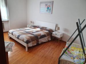 1 dormitorio con 1 cama y suelo de madera en Appartamento Valle dei Laghi, en Calavino