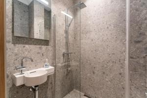 a bathroom with a sink and a shower at Studio 5 Min to Riga Old Town & Christmas Market in Rīga