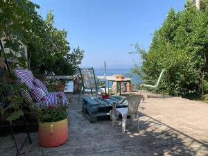 a patio with chairs and a table and the ocean at Zeleno i plavo in Kraljevica