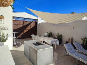 a patio with a table and chairs and a grill at Calymar in Sierra de Yeguas