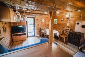 a room with a kitchen and a dining room at Wooden Cabin Zurej with Hot Tub in Bukovje v Babni Gori